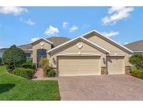 Inviting home featuring a three-car garage and meticulously maintained landscaping at 3710 Plymouth Dr, Winter Haven, FL 33884