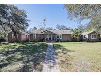 Charming single-story home with inviting brick path and well-manicured lawn on a sunny day at 4010 Paw Paw Trl, Lake Wales, FL 33898