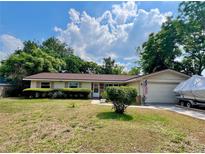 Charming single-story home features an attached garage and well-maintained landscaping at 799 W Lake Otis Dr, Winter Haven, FL 33880