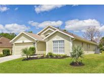 Charming single-story home featuring lush green lawn and well-manicured landscaping at 1942 Bermuda Pointe Dr, Haines City, FL 33844