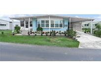 Charming home featuring a well-maintained lawn and an array of potted plants at 2055 S Floral Ave # 42, Bartow, FL 33830