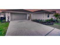 Charming home featuring a spacious driveway, two-car garage, and well-manicured landscaping at 409 Greenfield Rd, Winter Haven, FL 33884