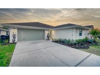 Charming single-story home featuring a well-manicured lawn, a two-car garage, and a freshly painted white exterior at 409 Greenfield Rd, Winter Haven, FL 33884