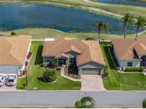 Aerial view of single-story home with beautiful landscaping, complemented by a serene pond and lush golf course backdrop at 4279 Ashton Club Dr, Lake Wales, FL 33859