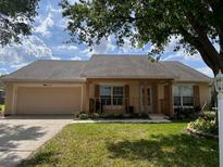 Charming single-story home with a well-manicured lawn, inviting porch, and attached two-car garage at 4337 Dinner Lake Dr, Lake Wales, FL 33859