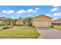 Charming single-story home with a well-manicured lawn, paved driveway, and lush tropical landscaping at 5341 Hogan Ln, Winter Haven, FL 33884