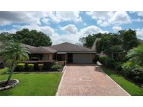 Charming single-story home with a well-manicured lawn and inviting brick driveway at 571 Saint Andrews Rd, Winter Haven, FL 33884