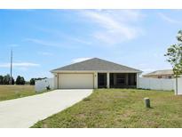 Charming single-story home with a well-manicured lawn, attached garage, and a classic design at 730 Colville Pl, Kissimmee, FL 34759