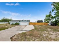 Charming single-story home features a spacious driveway, fenced backyard, and attached garage, perfect for comfortable living at 100 Ellen Ct, Winter Haven, FL 33884