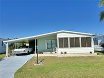 Charming single-story home featuring a carport and an enclosed sunroom at 11 Navel Dr, Winter Haven, FL 33884