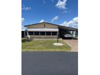 Charming single-story home with a well-manicured lawn, carport, and an anchor decoration on the front at 148 Sweet Cir, Winter Haven, FL 33884
