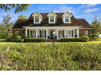Inviting home featuring a manicured front yard and a charming porch with rocking chairs at 195 E Conant St, Bartow, FL 33830