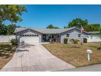 Charming single-story home featuring a two-car garage, a well-kept lawn, and a welcoming front porch at 210 Citrus Dr, Winter Haven, FL 33884