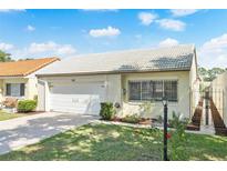 Charming single-story home with a white tile roof, well-maintained lawn, and attached one car garage at 259 Mariposa, Winter Haven, FL 33884