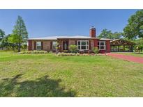 Charming single-story brick home featuring a well-manicured lawn, covered entry, and a classic brick chimney at 2726 Prine Rd, Lakeland, FL 33810