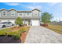 Charming townhome with gray siding, well-maintained landscaping, and a paved driveway leading to a one-car garage at 310 N 1St Ave, Bartow, FL 33830