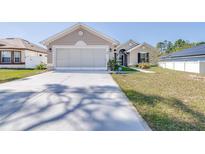 Charming single-story home featuring a wide driveway and well-maintained front lawn, with neutral stucco and white trim at 404 Rio Grande Ct, Poinciana, FL 34759
