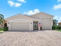 Charming single-story home with a three-car garage and a brick driveway, complemented by a well-manicured lawn at 4148 Dunmore Dr, Lake Wales, FL 33859
