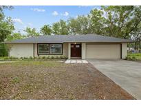 Charming single-story home with a two-car garage and beautifully maintained front yard at 6320 Newman E Cir, Lakeland, FL 33811
