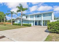 Charming two-story home with a metal roof, light blue siding and a long concrete driveway at 6925 Alturas Babson Park Cutoff, Bartow, FL 33830