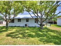 Charming single-story home with a metal roof and a well-maintained lawn with large trees at 117 Bream St, Haines City, FL 33844