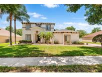 Charming two-story home featuring a manicured lawn, beautiful landscaping, and a welcoming entrance at 177 Costa Loop, Auburndale, FL 33823