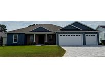 Charming single-story home with a brick facade, well-maintained lawn, and a two car garage with cobblestone driveway at 1781 Lakehill Dr, Winter Haven, FL 33884