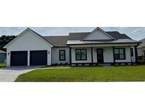 Charming single-story home featuring black trim, a manicured lawn and a two-car garage at 1787 Lakehill Dr, Winter Haven, FL 33884