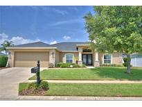 Charming single-story home featuring a manicured lawn, stone accents, and a two-car garage at 186 Viola Dr, Auburndale, FL 33823