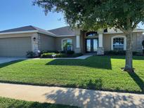 Charming home boasts a well-manicured lawn, double-door entrance, and stone accents at 186 Viola Dr, Auburndale, FL 33823
