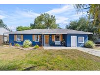 Charming blue home featuring a well-maintained lawn, wood shutters, and a welcoming front porch area at 275 Cherry Laurel Ln, Winter Haven, FL 33880