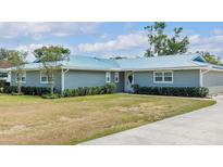 Charming single story home featuring a metal roof, mature landscaping, and a well-manicured lawn at 317 Oak Trl, Lakeland, FL 33813