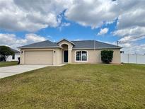 Charming single-story home featuring an attached garage and a well-maintained lawn at 351 Columbo St, Winter Haven, FL 33880