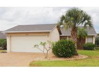 Charming single-story home featuring a lush palm tree, manicured landscaping, and a two-car garage at 4007 Cypress Lndg S, Winter Haven, FL 33884