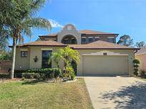 Charming home showcasing manicured landscaping, mature palms, and a spacious two-car garage at 4962 Sweet Cedar Cir, Orlando, FL 32829