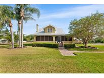 Charming two-story home with a well-maintained lawn, mature trees, and inviting front porch at 501 Main St, Lake Hamilton, FL 33851