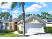 Charming single-story home featuring a 2-car garage, landscaped yard and a beautiful mature palm tree in the front at 662 Orista Dr, Davenport, FL 33897