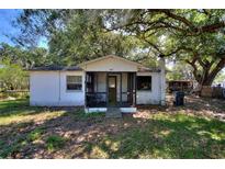 Charming single-story home features a screened-in front porch and mature trees at 6925 3Rd St, Mulberry, FL 33860
