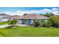 Charming single-story home featuring a lush green lawn, manicured garden beds, and a welcoming front porch seating area at 716 Maderia Ct, Kissimmee, FL 34758