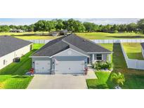 Charming single-story home with a three-car garage, landscaped yard, and beautiful curb appeal at 1045 Montgomery Ln, Polk City, FL 33868