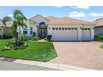 Charming home featuring a well-manicured lawn and a two car garage with a brick paved driveway at 1104 Sawgrass Dr, Winter Haven, FL 33884