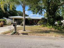 Charming single-story home with mature landscaping and a metal roof on a sunny day at 124 Palm Pl, Haines City, FL 33844