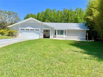 Charming single Gathering home with a well manicured lawn and two-car garage at 14 Cypress Run, Haines City, FL 33844