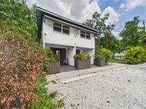 Charming two-story home with a gravel driveway, planter boxes and lush surrounding greenery at 2222 12Th Nw St, Winter Haven, FL 33881