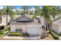 Charming single-story home featuring a well-manicured lawn and a two-car garage, nestled among mature trees at 2960 Kokomo Loop, Haines City, FL 33844