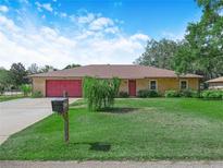 Charming single-story home with a well-manicured lawn, red accents, and inviting curb appeal at 4333 Shadow Wood Way, Winter Haven, FL 33880