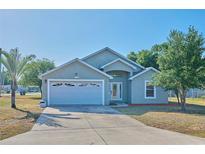 Charming single-story home with a two-car garage, lush landscaping, and a well-maintained front yard at 4703 Benton St, Lake Wales, FL 33859