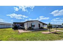 Charming single-story home with a well-maintained lawn, mature landscaping, and a covered carport at 6305 Bayberry Ne Blvd, Winter Haven, FL 33881