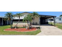Charming home with mature palm trees, well maintained lawn and covered parking at 6562 Chinaberry Ne Dr, Winter Haven, FL 33881