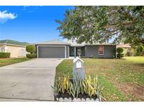 Charming single Gathering home features a well-manicured front yard with beautiful landscaping at 7120 Summit Dr, Winter Haven, FL 33884